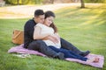 Pregnant Hispanic Couple in The Park Outdoors Royalty Free Stock Photo