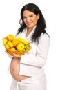 Pregnant holding full basket with fruits