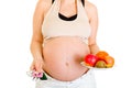Pregnant holding pills and fruits. Close-up. Royalty Free Stock Photo