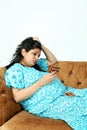 Pregnant irritate woman is holding medicine in hand