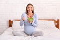 Pregnant Lady Enjoying Fresh Salad Sitting On Bed In Bedroom Royalty Free Stock Photo