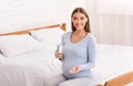 Pregnant Lady Holding Pill And Water Sitting In Bedroom Royalty Free Stock Photo