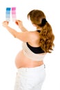 Pregnant looking at blue and pink paint samples Royalty Free Stock Photo