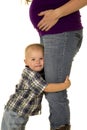 Pregnant mom in boots young boy hug her legs close Royalty Free Stock Photo