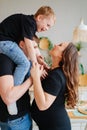 pregnant mom, dad rides son on shoulders. games and relationships with children Royalty Free Stock Photo