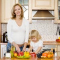 Pregnant mother and daughter in kitchen