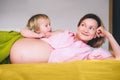 Pregnant mother and daughter together at home. Woman with her first child during second pregnancy. Motherhood and parenting Royalty Free Stock Photo