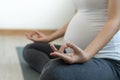Pregnant mother is doing yoga at home for good health. Pregnant women exercise and practice meditation for relaxation. Pregnancy y