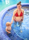 Pregnant mother with her child in swimming-pool Royalty Free Stock Photo