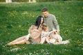 Pregnant mother and her little daughter and husband sitting on a grass in a park Royalty Free Stock Photo