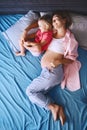 Pregnant mother with her little daughter relaxing in bed. Second pregnancy. Maternity and parenting concept Royalty Free Stock Photo