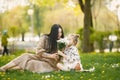 Pregnant mother and her little daughter sitting on a grass in a park Royalty Free Stock Photo