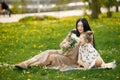 Pregnant mother and her little daughter sitting on a grass in a park Royalty Free Stock Photo