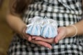 Pregnant mother holding baby blue shoes. Royalty Free Stock Photo
