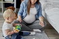 Pregnant mother playing toy blocks with her baby son Royalty Free Stock Photo