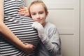 Pregnant mother and son at home. Cute boy with mom spending time together at home. Child boy hugging his mother pregnant tummy Royalty Free Stock Photo