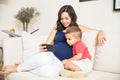 Pregnant Mother And Son Using Smartphone At Home Royalty Free Stock Photo