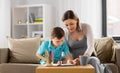 Pregnant mother and son with workbook at home