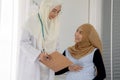 Pregnant muslim woman with her muslim female doctor in clinic, Gynaecology consultation