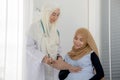 Pregnant muslim woman with her muslim female doctor in clinic, Gynaecology consultation