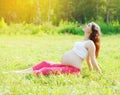 Pregnant pretty woman sitting on grass doing yoga exercise Royalty Free Stock Photo