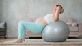 Pregnant red-haired woman doing exercises on fitness ball at home. Royalty Free Stock Photo