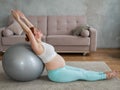 Pregnant red-haired woman doing exercises on fitness ball at home. Royalty Free Stock Photo