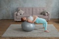 Pregnant red-haired woman doing exercises on fitness ball at home. Royalty Free Stock Photo