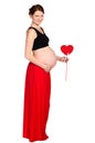 Pregnant in red skirt with paper heart in hands Royalty Free Stock Photo