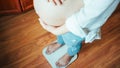 Pregnant scale gain weight. Happy pregnancy woman standing on weight scales. Concept maternity, pregnancy, childbirth. Royalty Free Stock Photo