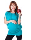 A pregnant smiling woman is holding an apple