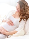 Pregnant smiling woman sitting on a sofa Royalty Free Stock Photo