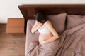 Pregnant suffering with nausea. Pregnancy symptoms, expectation toxicosis. Young vomiting woman sitting on bed. parenthood concept Royalty Free Stock Photo