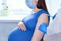 Pregnant Vaccination. Pregnant Woman In Face Mask Getting Vaccinated in Hospital. Doctor Giving Corona Virus Vaccine Injection Royalty Free Stock Photo