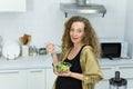 pregnant vegetarian woman smile, happy, stand, eat vegetable, look at camera in kitchen with copy space. beautiful caucasian Royalty Free Stock Photo