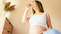 Pregnant water drinking woman. Young pregnancy mother drink water. Pregnant lady waiting of baby. Glass of water Royalty Free Stock Photo