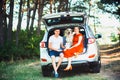 Pregnant wife, husband and dog sitting in a car Royalty Free Stock Photo