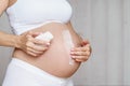 Pregnant woman aplying cream at her belly for prevention of stretch marks on the skin Royalty Free Stock Photo