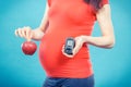 Pregnant woman with apple and glucometer with good result sugar level, diabetes and nutrition during pregnancy Royalty Free Stock Photo