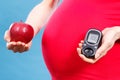 Pregnant woman with apple and glucose meter with good result sugar level, diabetes and nutrition during pregnancy Royalty Free Stock Photo