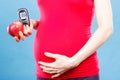 Pregnant woman with apple and glucose meter with good result sugar level, diabetes and nutrition during pregnancy Royalty Free Stock Photo