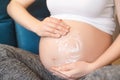 Pregnant woman applying cream on her belly Royalty Free Stock Photo