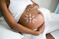 Pregnant woman applying cream on her belly Royalty Free Stock Photo