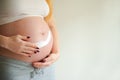 A pregnant woman is applying cream to her stomach for stretch marks. Pregnant tummy, oil for skin elasticity. Pregnant cares for h Royalty Free Stock Photo