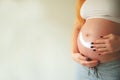 A pregnant woman is applying cream to her stomach for stretch marks. Pregnant tummy, oil for skin elasticity. Pregnant cares for h Royalty Free Stock Photo