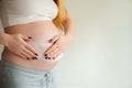 A pregnant woman is applying cream to her stomach for stretch marks. Pregnant tummy, oil for skin elasticity. Pregnant cares for h Royalty Free Stock Photo