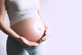 Pregnant woman applying moisturizer cream on her belly. Body skin care during pregnancy Royalty Free Stock Photo