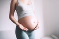 Pregnant woman applying moisturizer cream on her belly. Body skin care during pregnancy Royalty Free Stock Photo