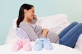 Pregnant woman with baby booties on a table