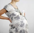 Pregnant woman with a baby bottle. Conceptual image shot Royalty Free Stock Photo
